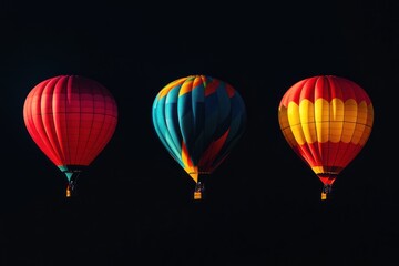 Obraz premium Three Colorful Hot Air Balloons Against a Dark Sky