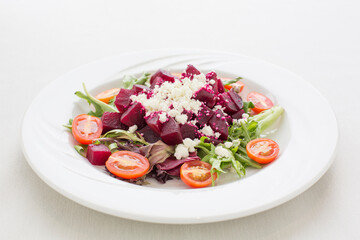A plate of food with tomatoes, beets, and cheese