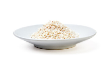 Psyllium husk powder on white plate isolated on white background. Psyllium husk has increasing the volume of feces and amount of water in the intestines, It's used as a laxative to treat constipation.