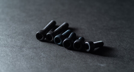 黒背景に置いてある沢山のネジ