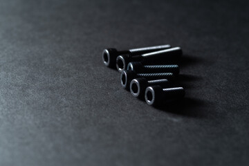 黒背景に置いてある沢山のネジ