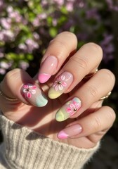 Floral pastel manicure with french tip highlights against spring blossoms