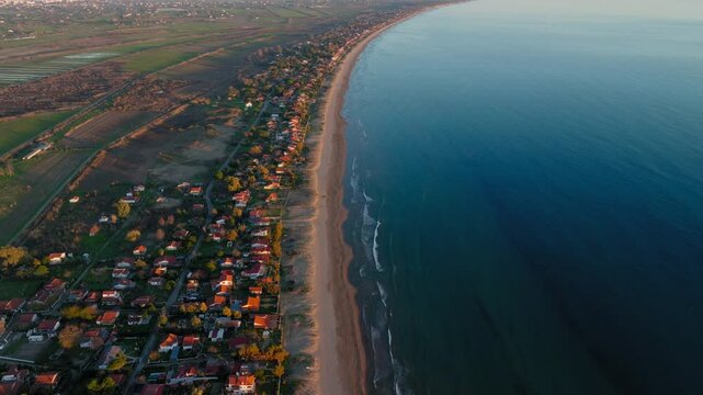 Aerial: Panoramic view of Letrina beach and the arbitrary houses near the sea. The longest sandy beach in europe