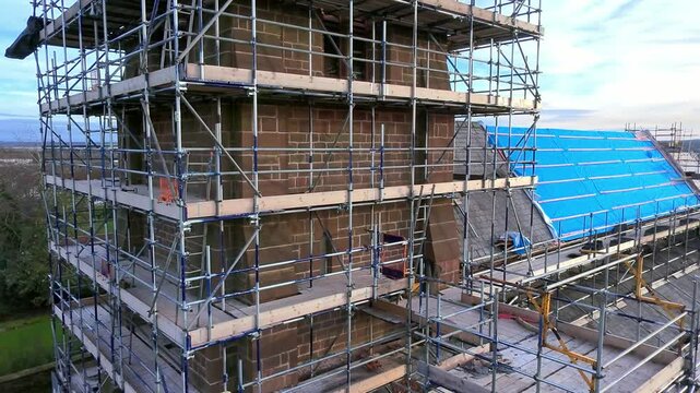 Church steeple tower scaffolding framework aerial view passing roof architecture reconstruction