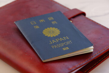 パスポート（5年用紺色）とシステム手帳（トラベラーズノート）で、海外旅行を計画しているイメージ
