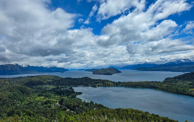Scenic View of Lakes and Green Islands Surrounded by Rolling Hills Under a Vibrant Blue Sky with...