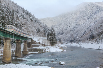 雪に覆われた第13宮川橋梁を雪煙を上げて駆け抜ける高山本線