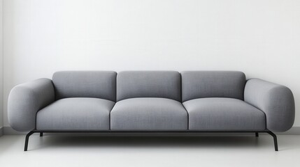 A gray couch with a black frame sits in a white room