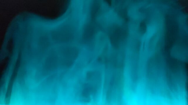 Close-up of smoke with light blue color rising, calming and abstract visual effect.