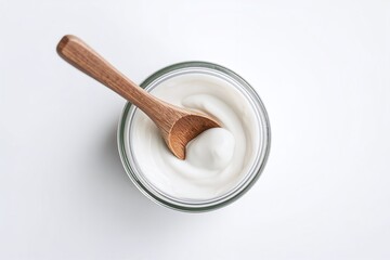 A wooden spoon in a glass bowl of creamy yogurt, symbolizing probiotics and gut health. Visual appeal for audiences interested in wellness and healthy eating.