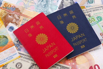 日本のパスポート（一般旅券10年用赤色と一般旅券5年用紺色）と海外のお金で、海外旅行のイメージ
