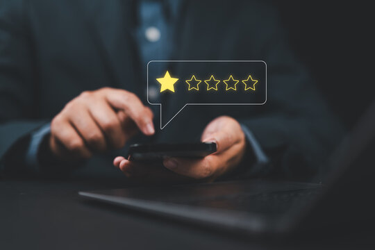 Negative customer review concept. Man a smartphone to give a one-star rating, symbolizing customer dissatisfaction, negative feedback, and online reviews in business reputation. 1 star score,