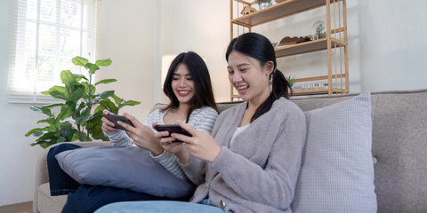 Fototapeta premium Joyful lesbian couple playing games together at home lifestyle content cozy living room intimate viewpoint