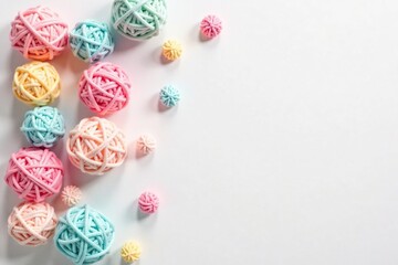 Soft pastel pom poms scattered on a white background, yarn balls, whimsical ornaments, pastel colors fabric balls