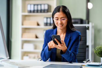 Fototapeta premium A businesswoman sits at her desk in a modern office, working on a laptop. She browses an online banking website, managing finances, analyzing transactions, and making strategic business decisions.