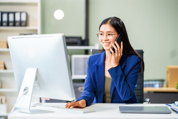 A businesswoman sits at her desk in a modern office, working on a laptop. She browses an online banking website, managing finances, analyzing transactions, and making strategic business decisions.