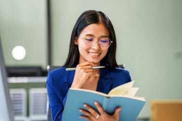 Naklejka premium A businesswoman sits at her desk in a modern office, working on a laptop. She browses an online banking website, managing finances, analyzing transactions, and making strategic business decisions.