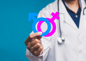 Doctor holding gender symbols, male and female signs in focus, healthcare and equality concept