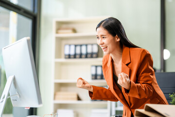 A beautiful Asian businesswoman works at her desk, exuding professionalism and focus.She is deeply...