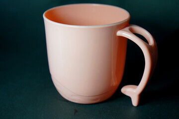 Soft Pink Mug: A pastel pink plastic mug with a simple design, set against a dark background, exuding a soft and minimalist vibe.