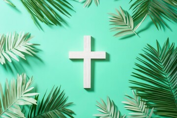 Palm Sunday. Wooden christian cross and palm leaves on green pastel background, top view, copy space. Palm sunday festival concept. 