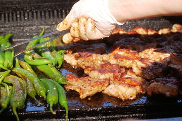 Beef and chicken steaks on the grill with flames.
