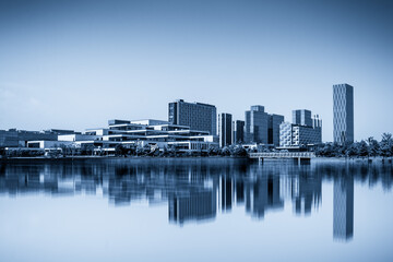 Obraz premium Modern Urban Skyline Reflected on Tranquil Water Surface