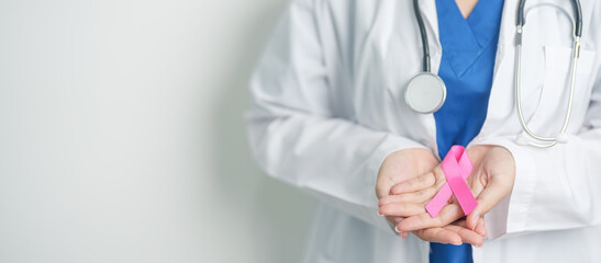 Pink October Breast Cancer Awareness month, woman doctor with pink Ribbon in hospital for support people life and illness. National cancer survivors month, Mother and World cancer day concept