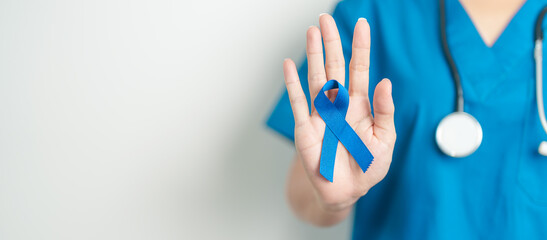 March Colorectal Cancer Awareness month, doctor with dark Blue Ribbon for supporting people living and illness. Healthcare, hope and World cancer day concept