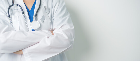 Brain Cancer Awareness May month, Doctor with grey color Ribbon for supporting life people. Healthcare and World cancer day concept