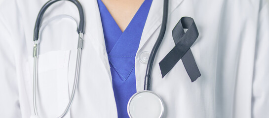 Melanoma and skin cancer, Vaccine injury awareness month and rest in peace concepts. doctor holding black Ribbon