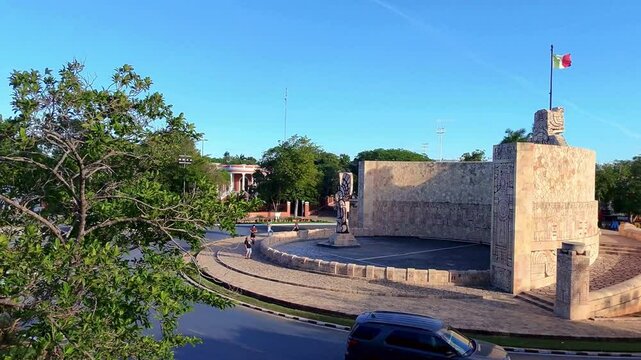 Monumento a la Patria en Paseo Montejo, M&eacute;rida, con calles, edificios y bandera de M&eacute;xico. Captura la vida urbana y belleza hist&oacute;rica de la ciudad de M&eacute;rida, Yucat&aacute;n.