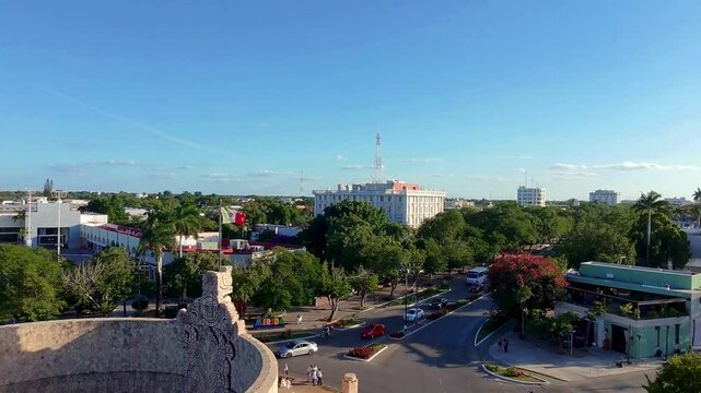 Monumento a la Patria en Paseo Montejo, M&eacute;rida, con calles, edificios y bandera de M&eacute;xico. Captura la vida urbana y belleza hist&oacute;rica de la ciudad de M&eacute;rida, Yucat&aacute;n.