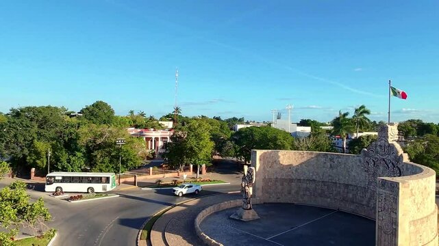 Monumento a la Patria en Paseo Montejo, M&eacute;rida, con calles, edificios y bandera de M&eacute;xico. Captura la vida urbana y belleza hist&oacute;rica de la ciudad de M&eacute;rida, Yucat&aacute;n.