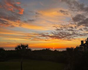 Fototapeta premium Fiery Coastal Sunset with Silhouettes of Palm Trees