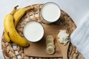 Bebida de kéfir fermentada con probióticos, granos kéfir sobre una cuchara de madera, kéfir preparado con banana. 