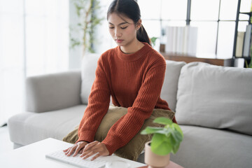 Beautiful asian Woman working by using wireless bluetooth white keyboard computer Hands typing on...