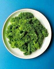 Fototapeta premium Fresh green kale leaves on a white plate and blue background