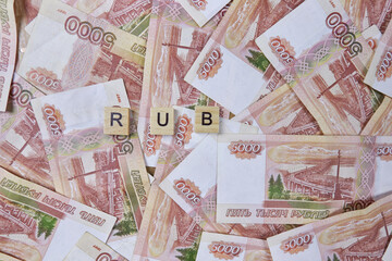 Background of five thousand Russian ruble banknotes with inscription RUB on wooden block, top view, copy space. currency exchange, accumulation of cash, banking system