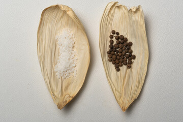 Especias para tamales, sal, pimienta, laurel sobre una hoja seca de maíz, cocina tradicional...