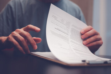 Fototapeta premium Document and data analysis concept, man hand holding or handing over document paperwork on clipboard, documentation, document data management system