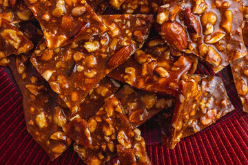 Homemade sweet gozinak with various nuts on a red plate, Christmas concept