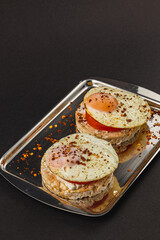 Sandwiches with egg on rice bread with tomato on a plate on a black background