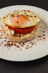 Egg sandwiches on rice bread on a white plate on a black background