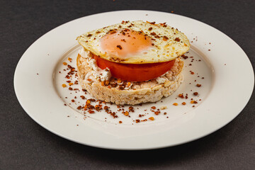 Egg sandwiches on rice bread on a white plate on a black background