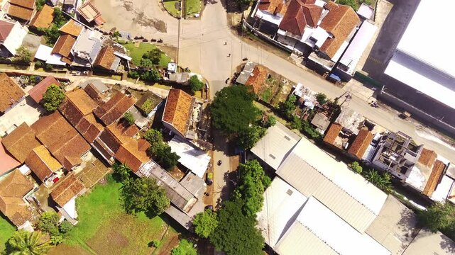 Aerial Footage of Village Street with T-junction. Gas Station is located at a strategic T-junction. View of the activities of residents' lives on a street. An alternative route