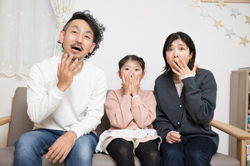 テレビや何かを見て驚く家族　カメラ目線
