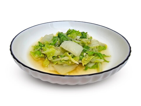 Vegetable Dish Stir Fried Chinese Cabbage served on a white plate isolated on white background. Sauted napa cabbage with chopped garlic or tumis sawi putih. Vegan, healthy Indonesian food.