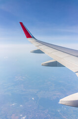 Fototapeta premium View from the airplane window at a beautiful cloudy sky and the airplane wing