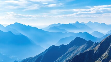 Majestic, serene mountain range under blue sky, hazy horizon